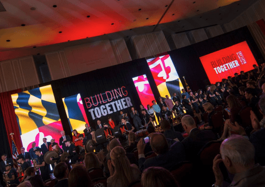 Cover of Giving Newsletter November 2017. People on a stage with the words 'Building Together' in bold hung behind the stage