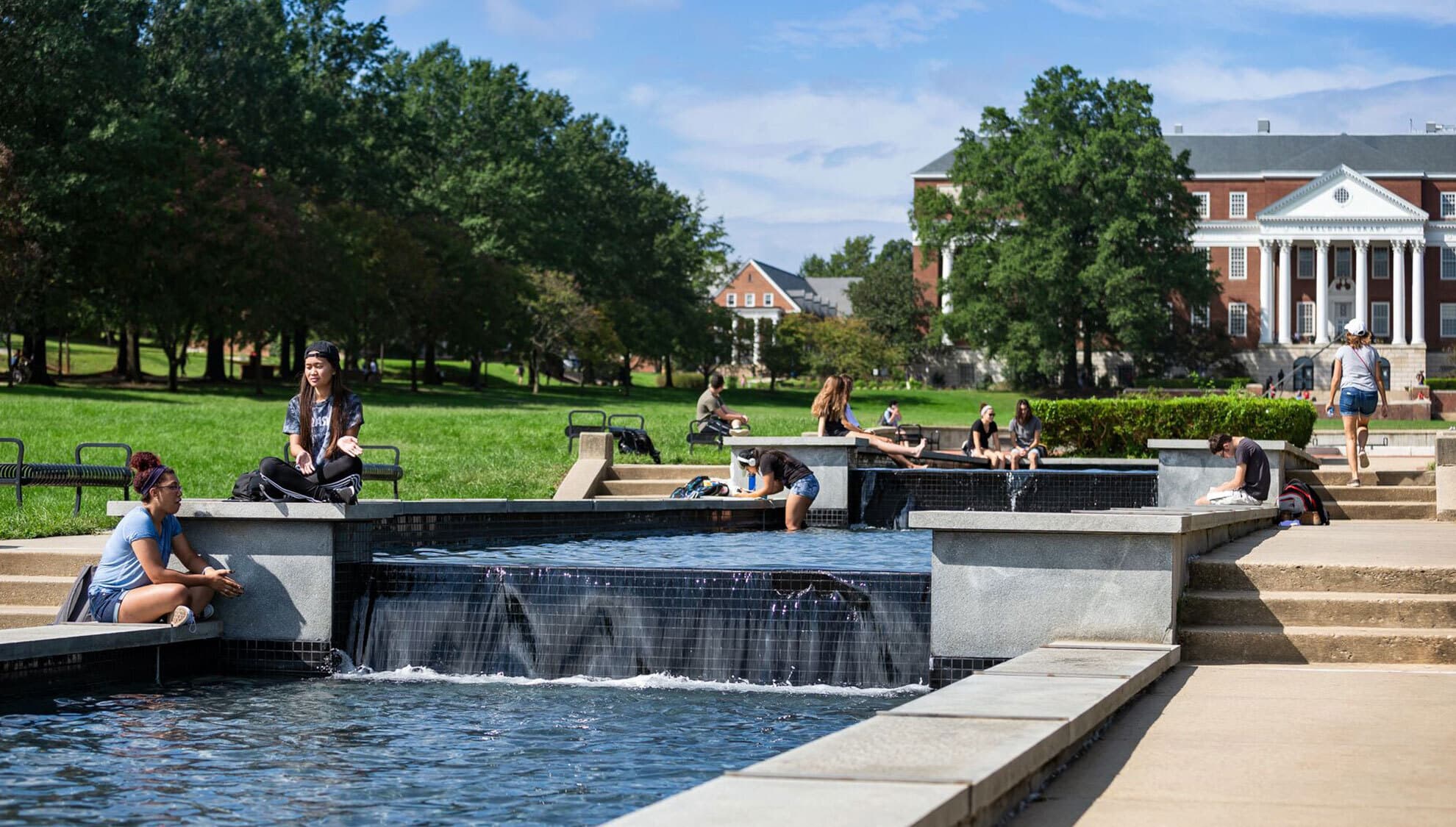Students sitting by the fountain in McKeldin Mall on a sunny day